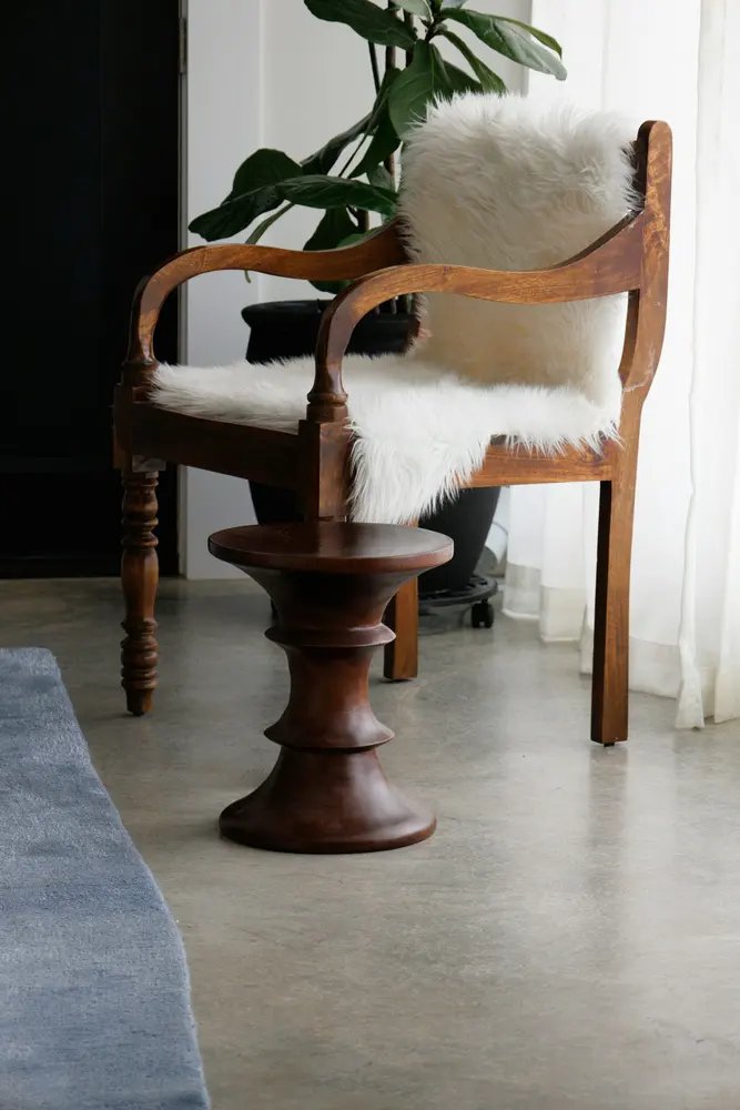 wooden armchair with fluffy white seat cover and back cushions