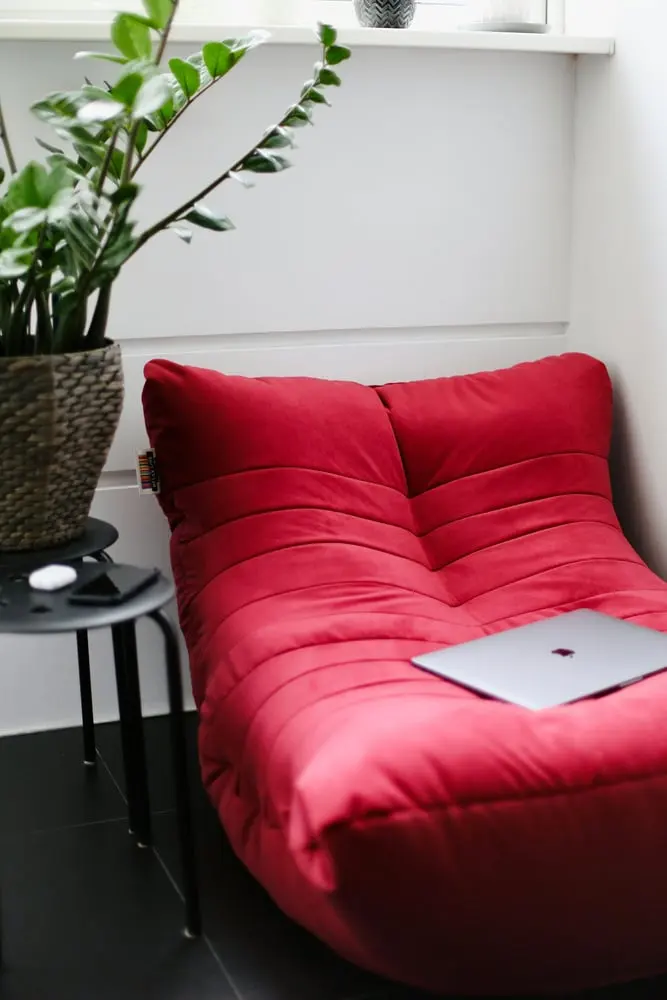 silver macbook on red couch