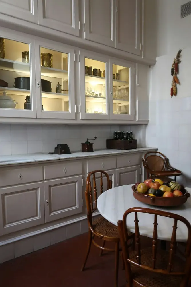 white kitchen with illuminated cabinets marble table and fruit