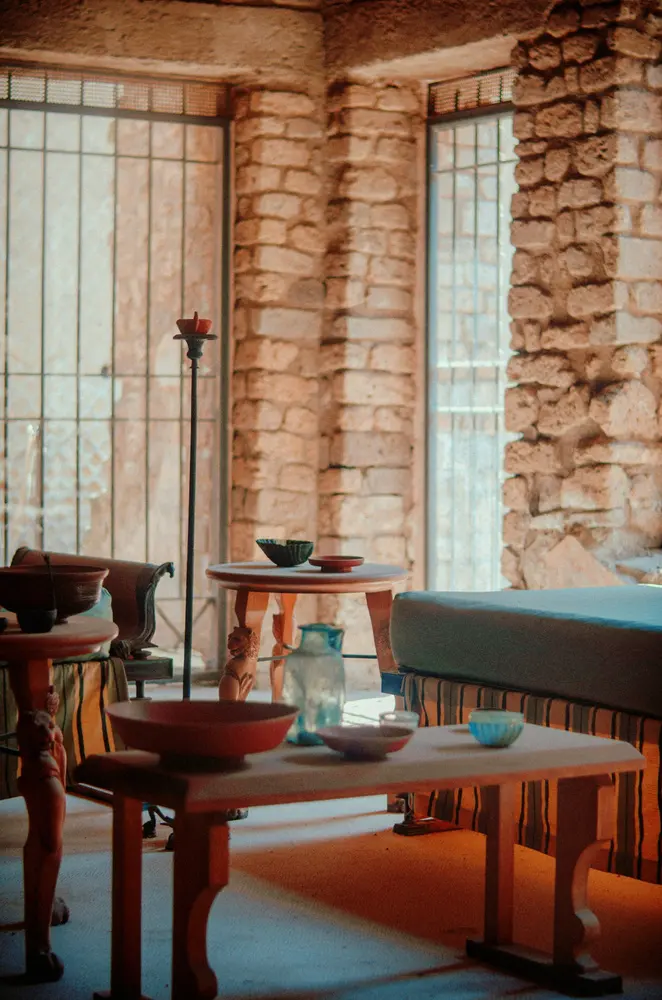 a room filled with furniture and a stone wall