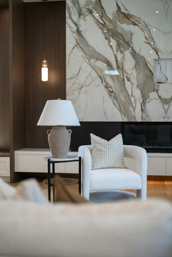 modern living room with white armchair lamp and marble wall
