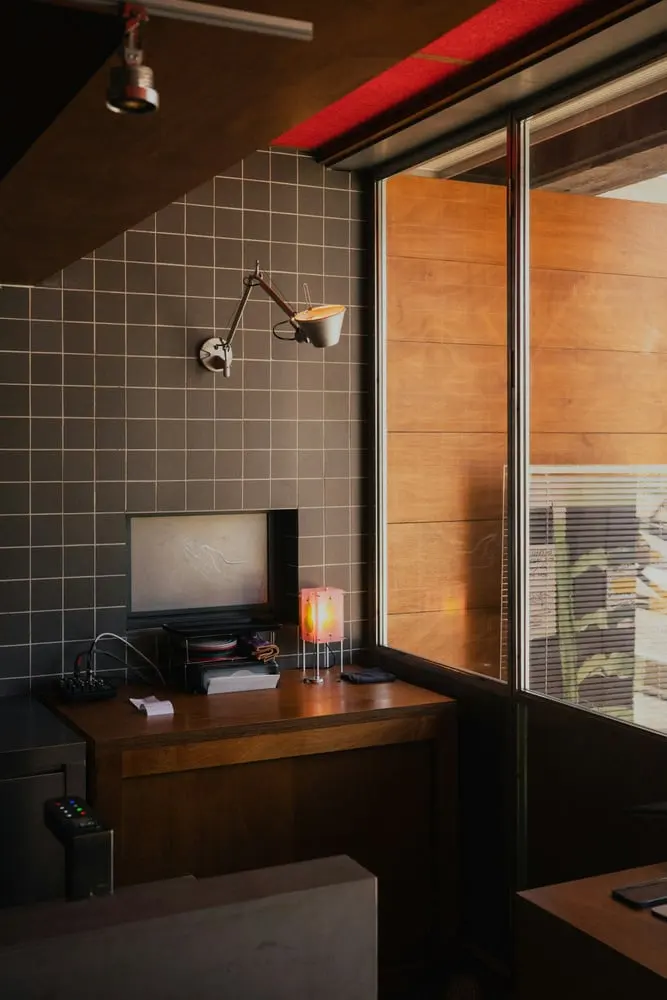 a desk with a computer and lamp in a room