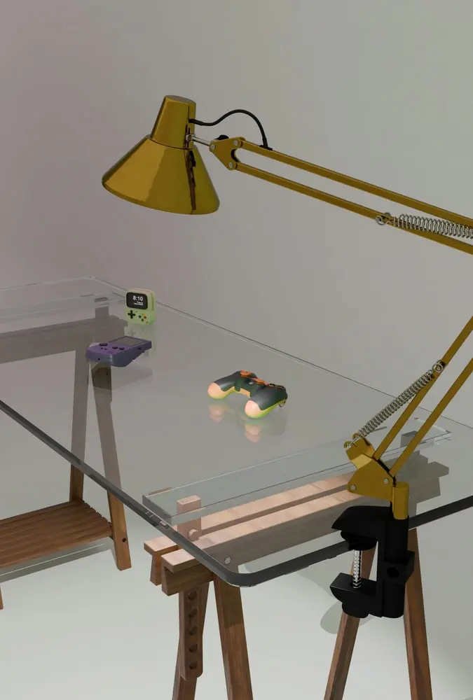 yellow desk lamp illuminates retro gaming consoles on glass desk