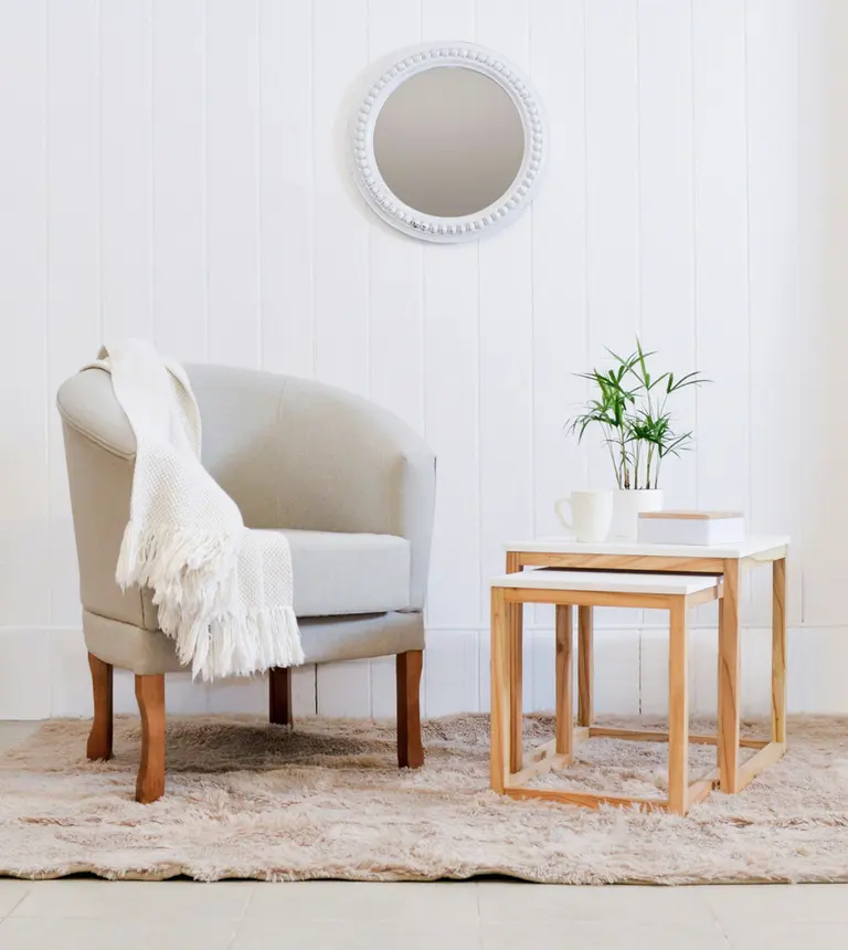 a cozy armchair with a throw blanket and side tables